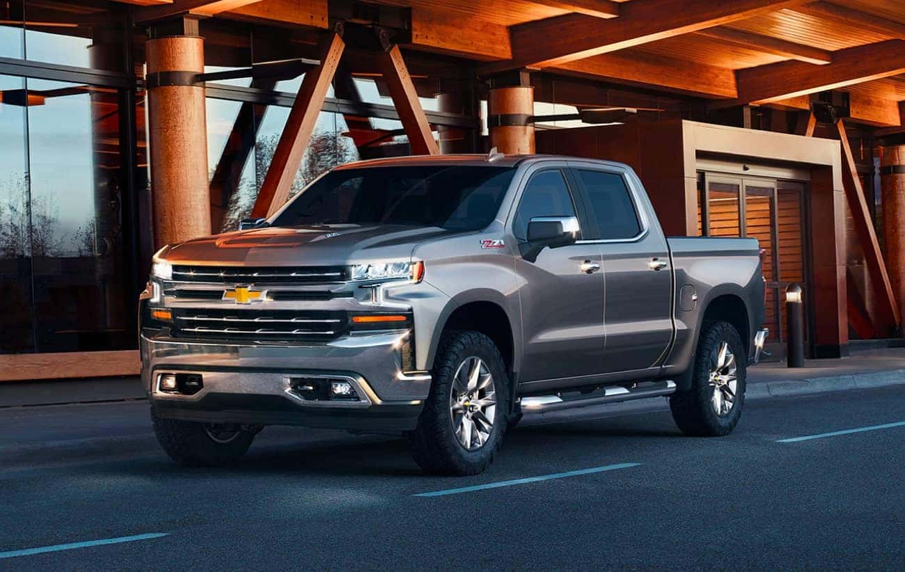 Grey Chevrolet Silverado 1500 parked outside a modern wooden building