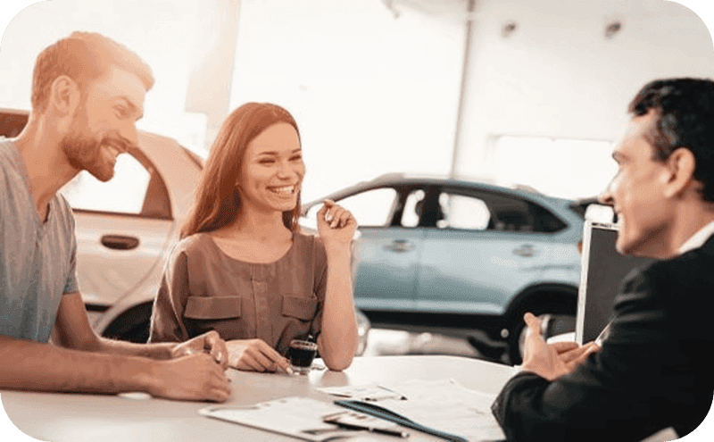 A couple sitting with a dealership finance advisor