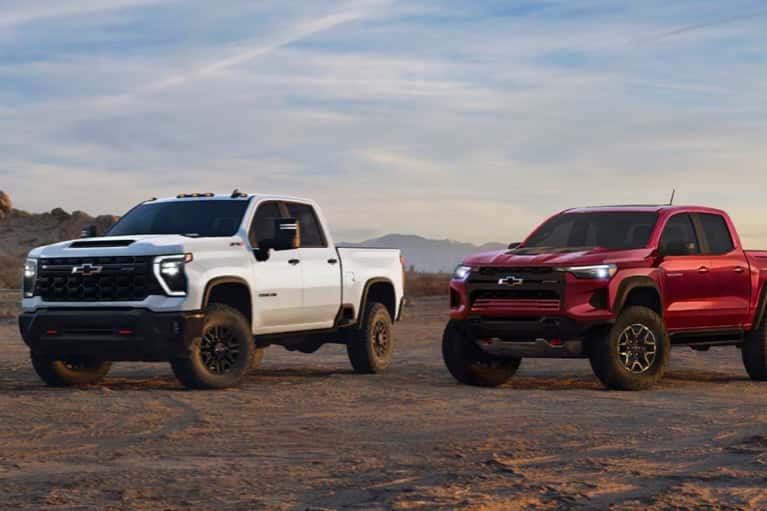 2025-Chevrolet-trucks-in-row-on-dirt-at-sunset-mobile