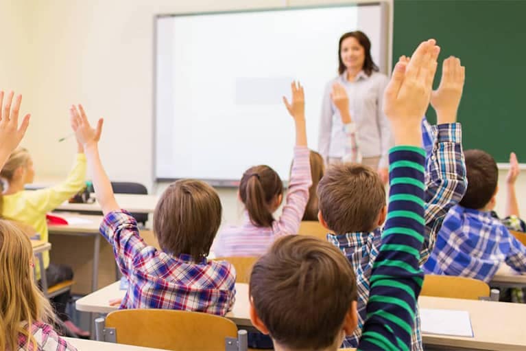Children Raising Hands for Teacher in Classroom mobile