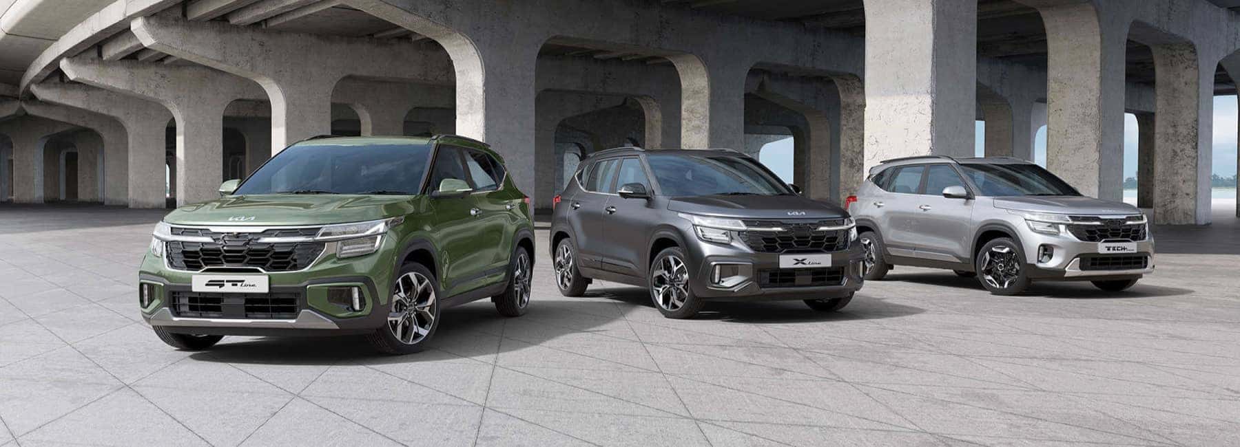 Kia vehicles parked near a bridge