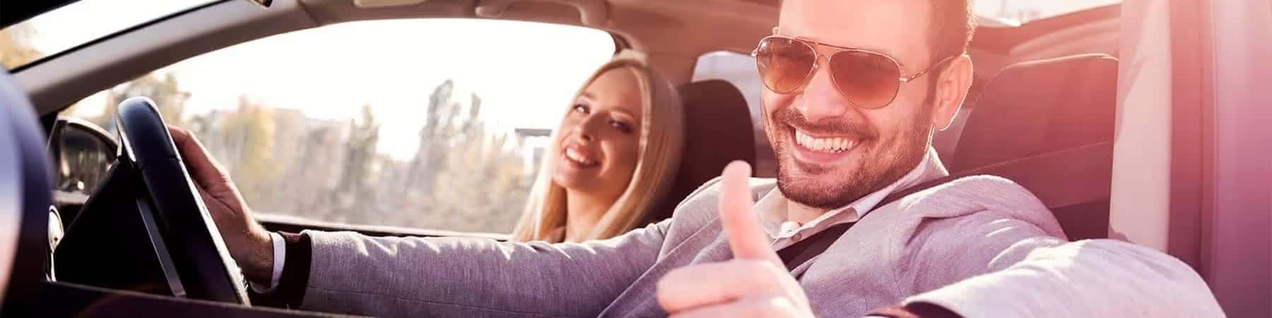 man driving car giving thumbs up
