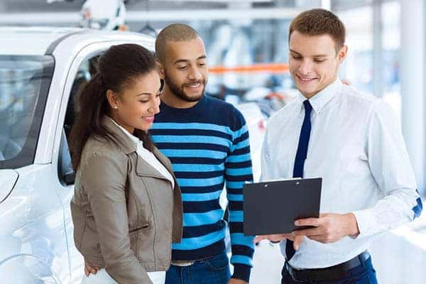 Two people buying a car from a salesperson