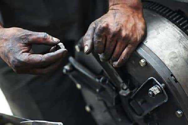 Hands fixing a cars breaks