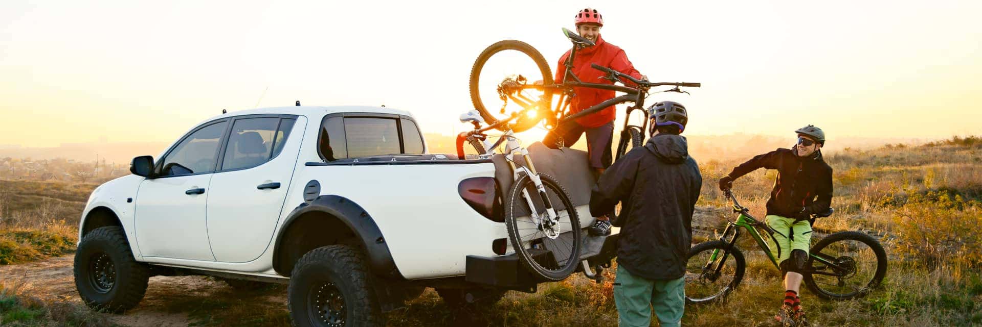 group of people taking bikes out of the truck of bed