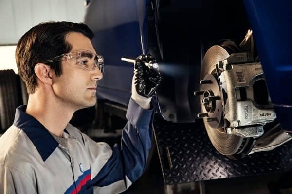 Service mechanic looking at brakes on a vehicle
