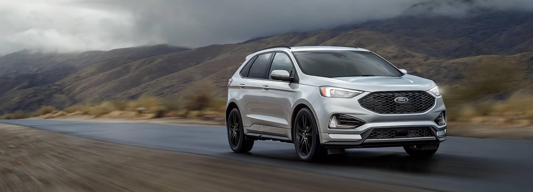 Silver 2021 Ford Edge driving along a foggy mountain pass