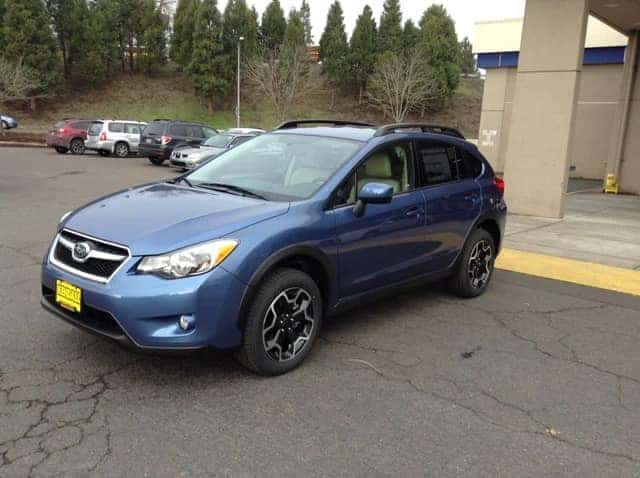 blue subaru on lot with trees