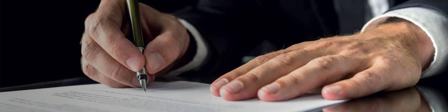 Hands of Man in Suit Signing Documents