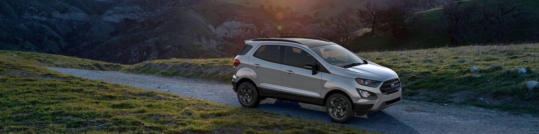 Silver 2021 Ford EcoSport overlooking the sunset behind a mountain range