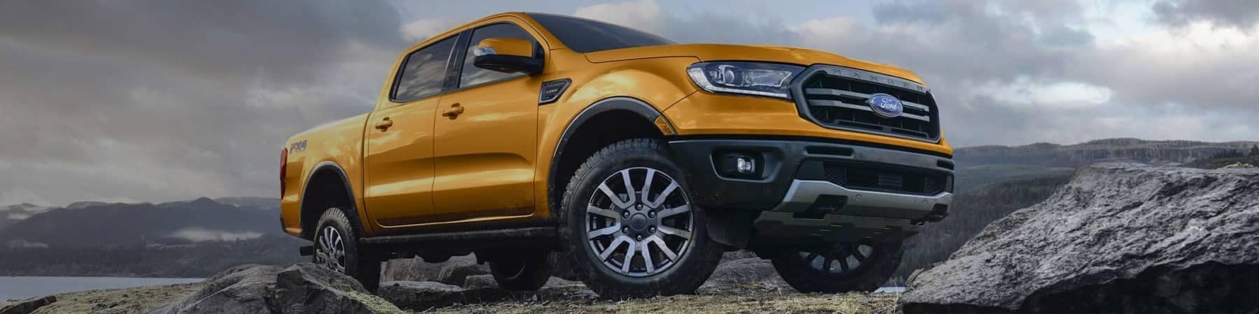 2021 Ford Ranger in Saber on rocky terrain with a body of water in background