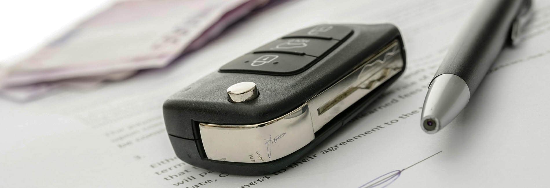 Car key lying on finance docs