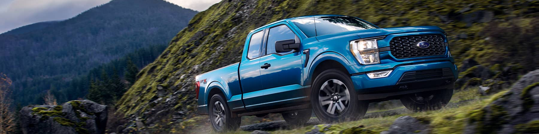 Blue 2021 Ford F-150 climbing a mountain road