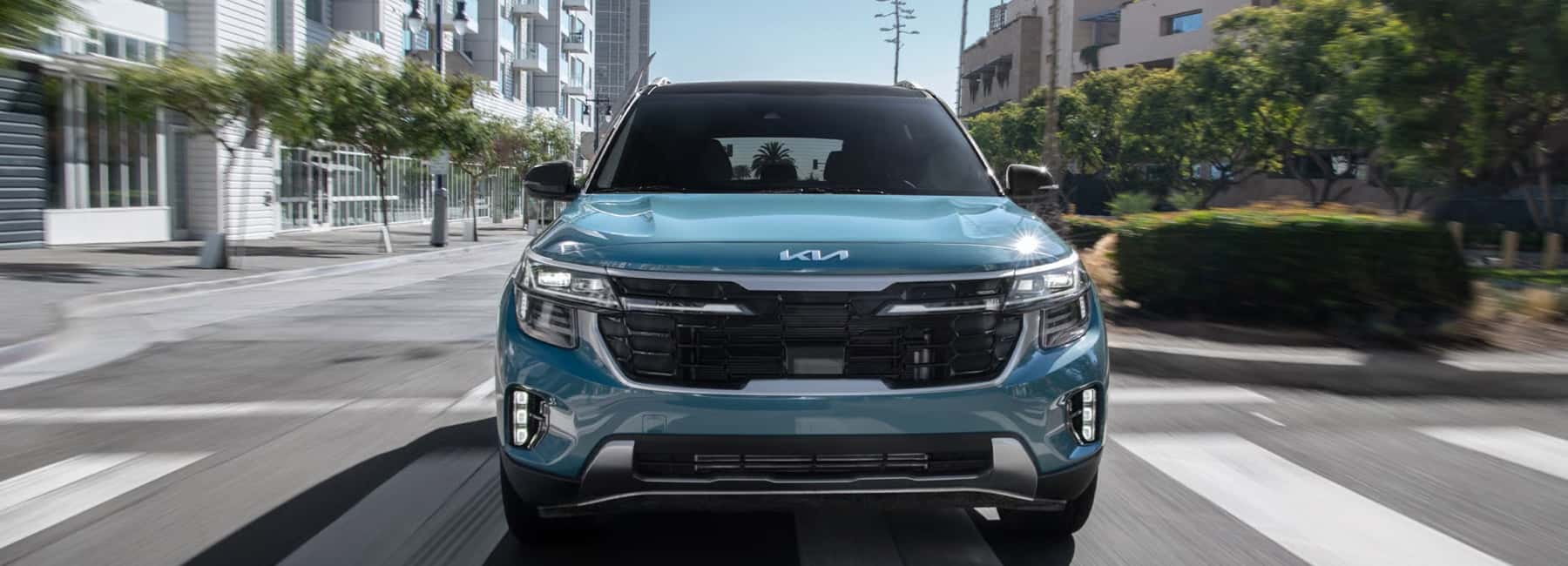 2025-Kia-Seltos-drives-tree-lined-city-street