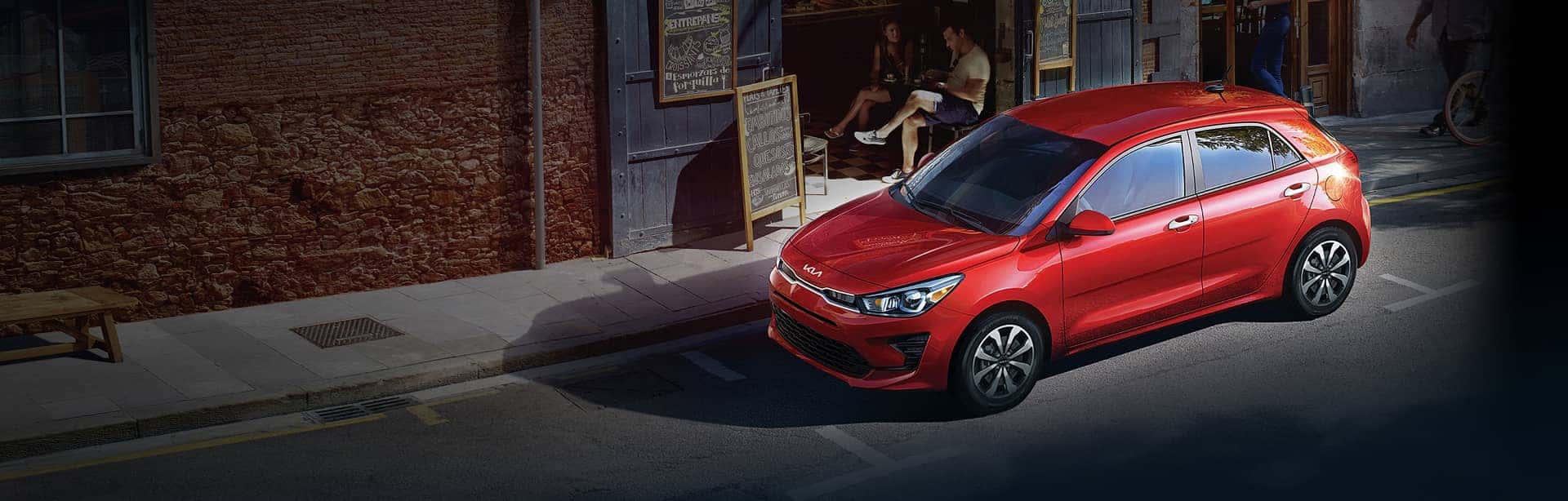 orange-kia-parked-outside-cafe