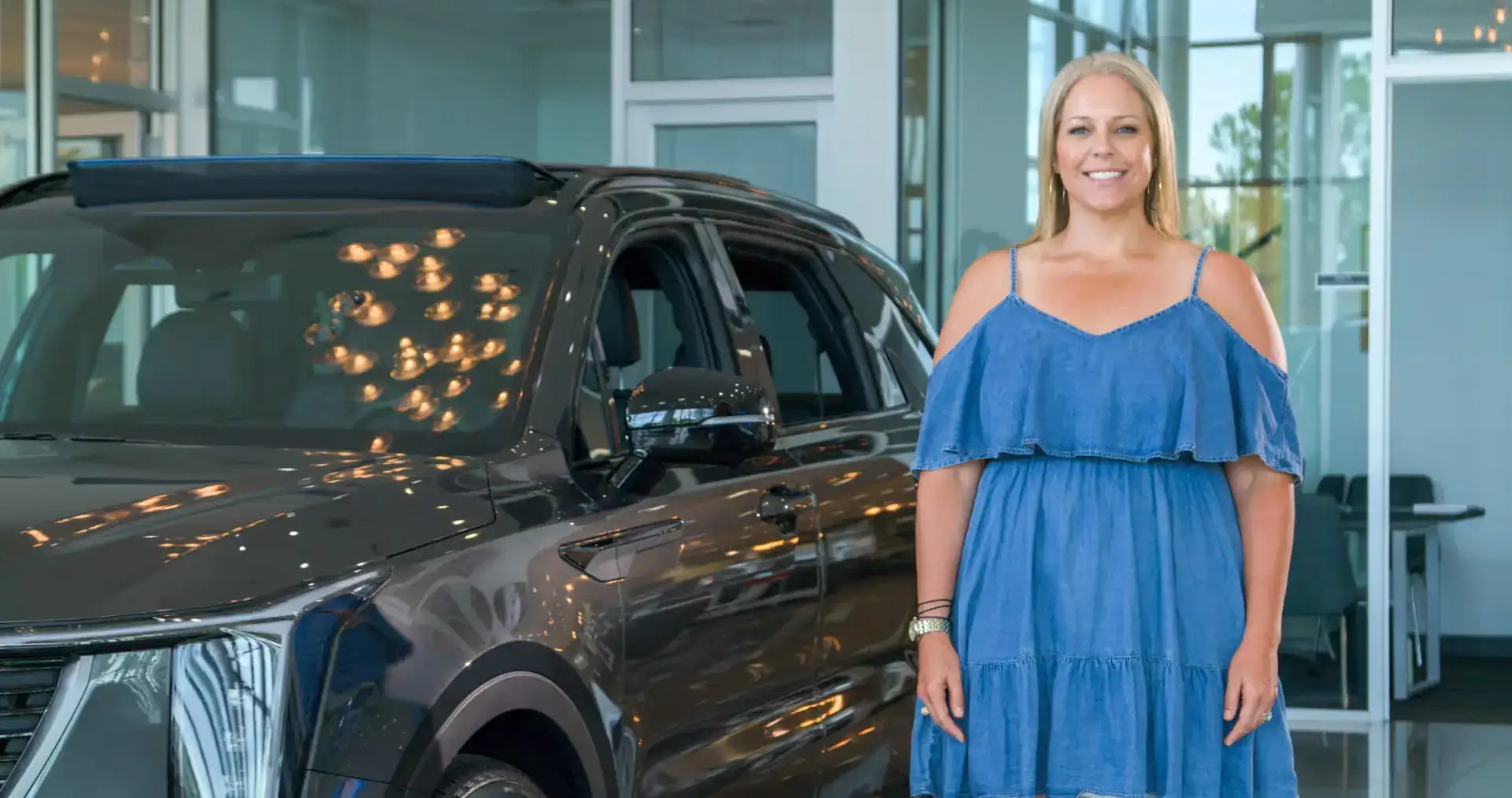Woman in front of car in showroom