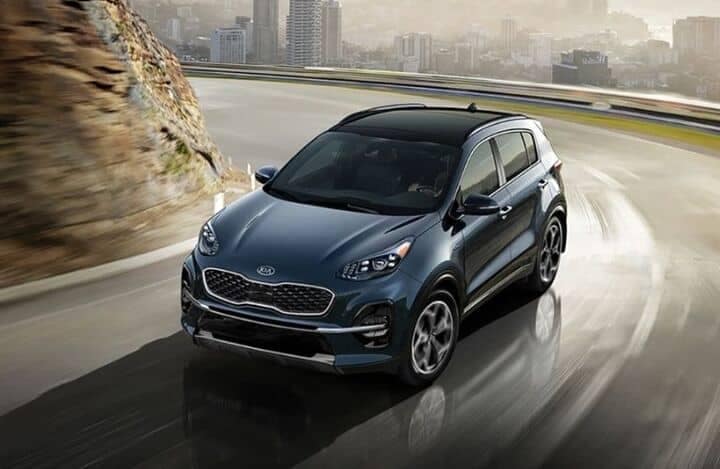 Frontview of a 2022 Blue Kia Sportage cruising on a road