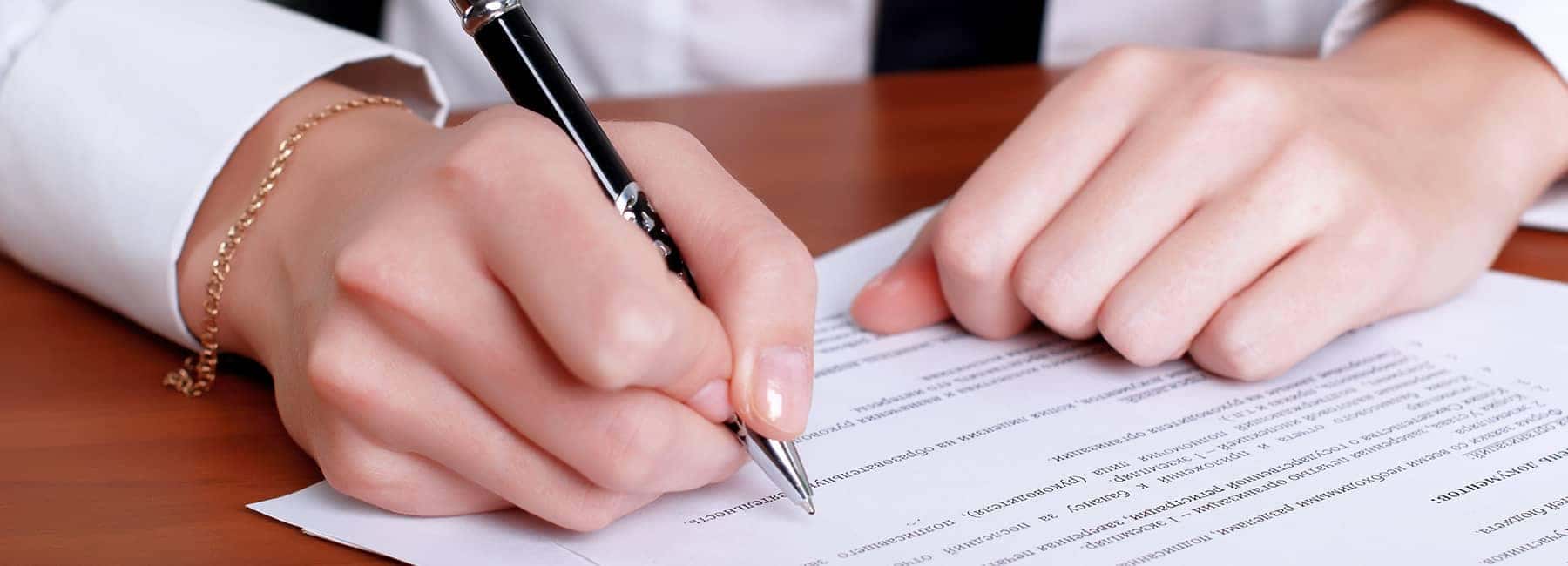 hand signing papers with pen