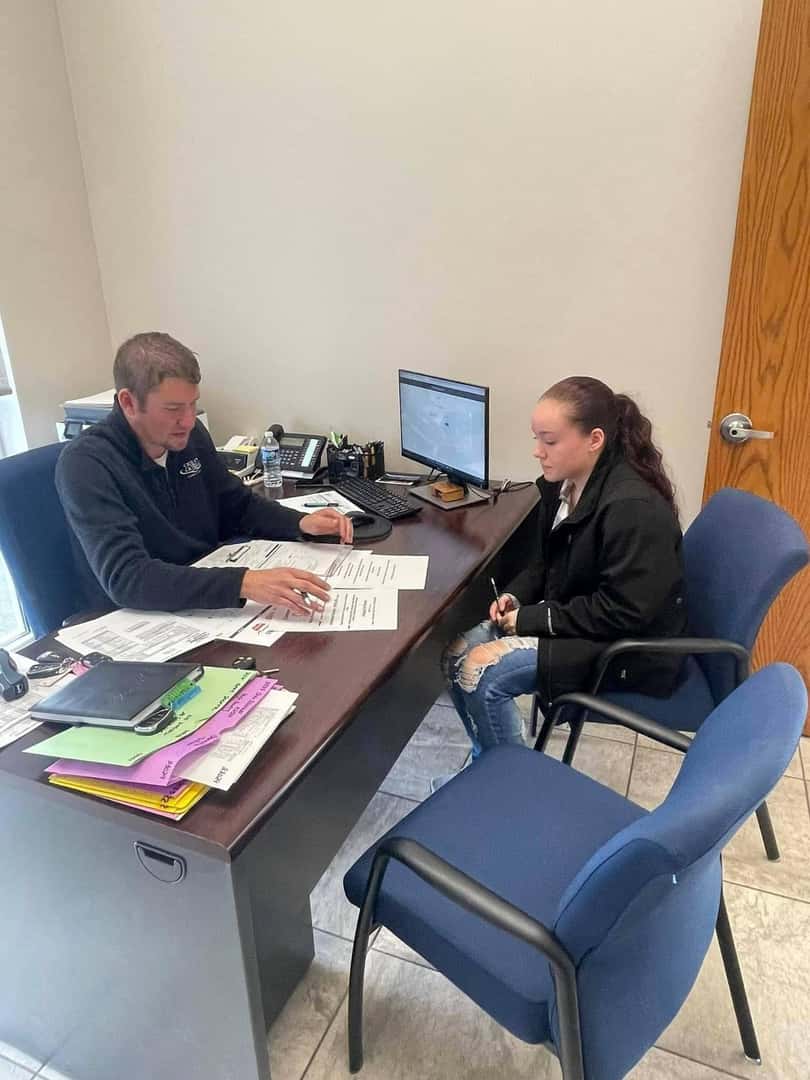 young-person-at-desk-talking-to-sales-rep
