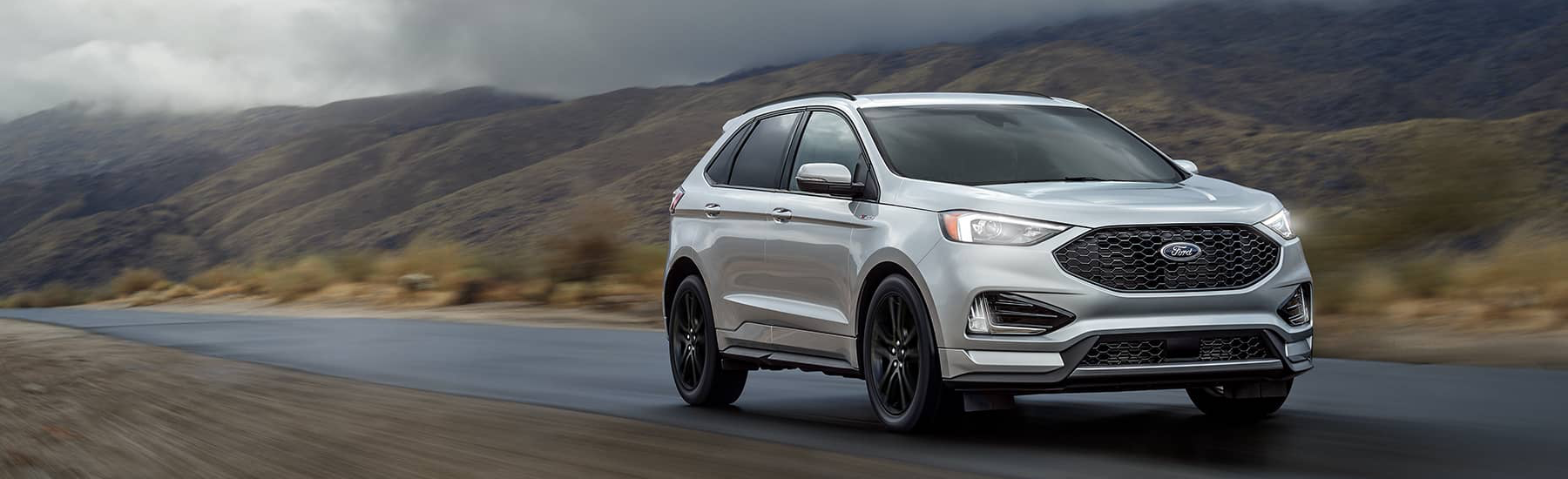 Silver 2021 Ford Edge driving along a foggy mountain pass