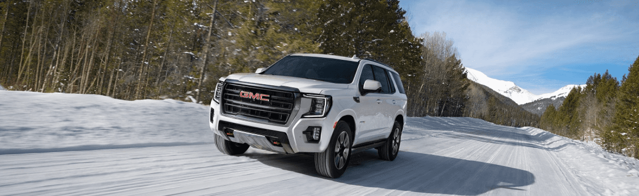 White GMC SUV driving on the snow