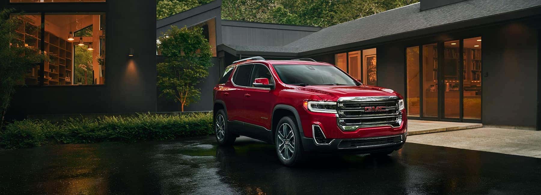 Red 2020 GMC Acadia parked in front of home