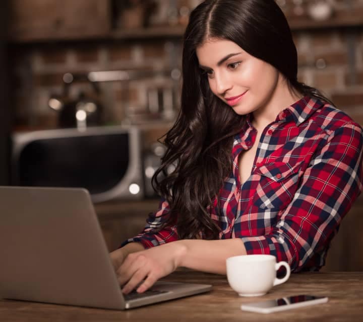 woman with coffee and laptop searching the internet