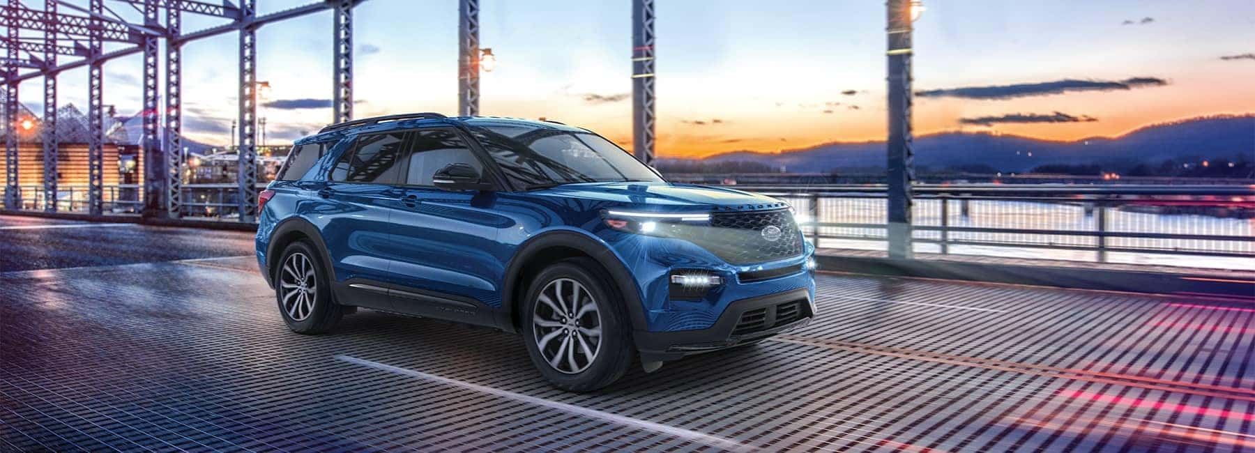 Blue 2021 Ford Explorer crossing a suburban bridge