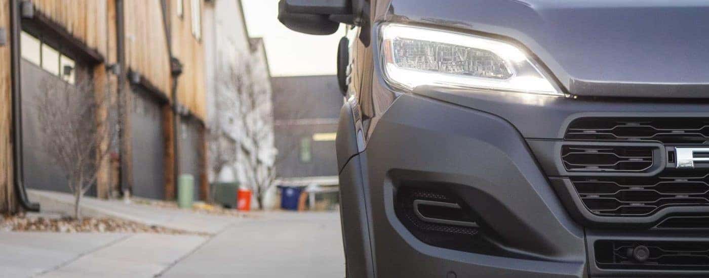A close up shows the passenger side headlight on a grey 2023 Ram ProMaster.