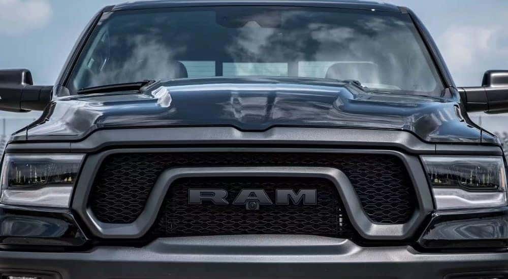 A close up shows the grille and headlights on a black 2024 Ram 1500 after leaving a Ram dealer.