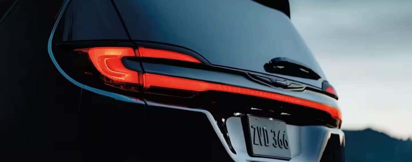 A close up shows the driver side taillight on a black 2024 Chrysler Pacifica Hybrid.