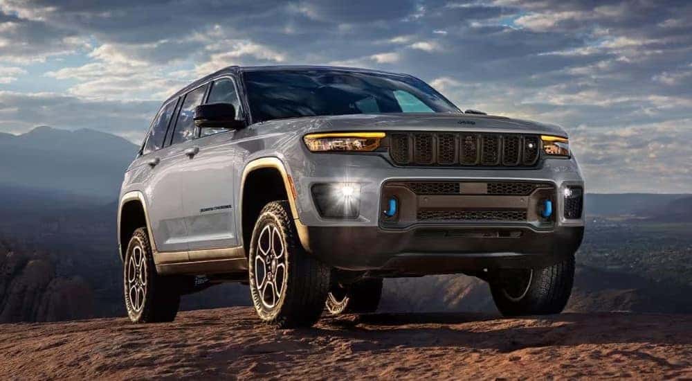 A silver 2024 Jeep Grand Cherokee 4xe is shown off-road.