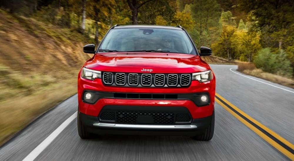 A red 2024 Jeep Compass is shown driving to a Charlotte Jeep dealer.