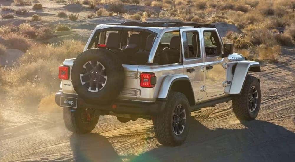 A silver 2024 Jeep Wrangler 4xe is shown from the rear.