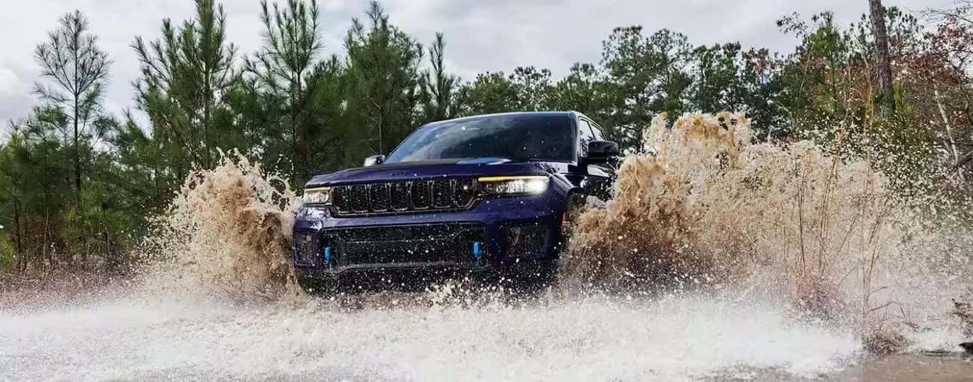 A purple 2024 Jeep Grand Cherokee 4xe is shown driving off-road.