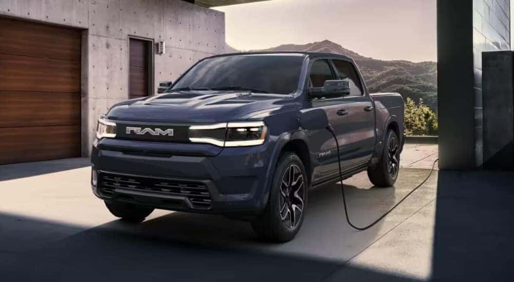 A blue 2024 Ram 1500 REV is shown charging after leaving a Ram dealer near Concord.