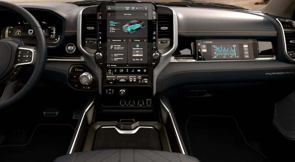 A close-up shows the infotainment screen in a 2024 Ram 1500 REV Tungsten.