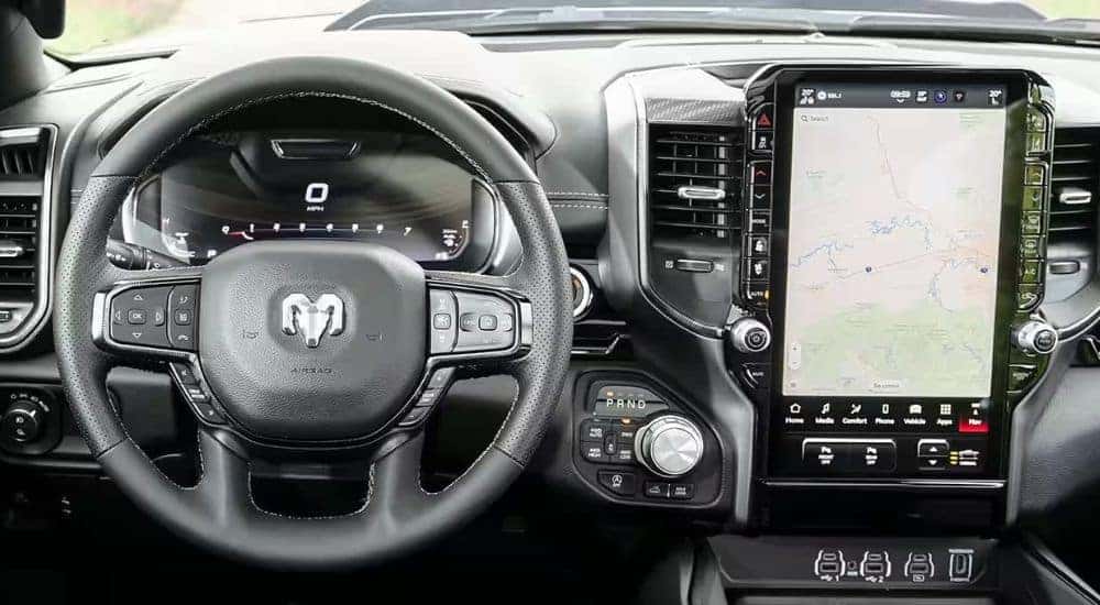 A close-up shows the black dash and infotainment screen in a 2025 Ram 1500.