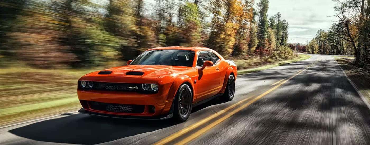 An orange 2023 Dodge Challenger SRT Super Stock is shown from the front at an angle.