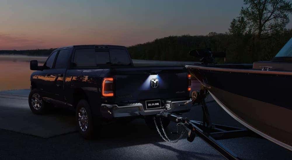 A dark blue 2024 Ram 2500 towing a boat.