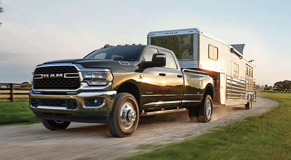 A grey 2024 Ram 3500 is shown towing a trailer.