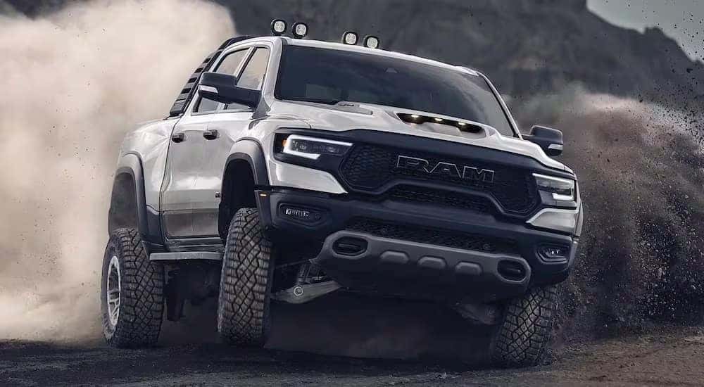 A white 2024 Ram 1500 TRX is shown driving off-road.