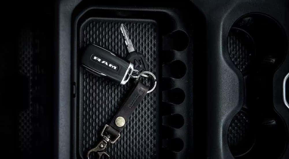 A close-up of keys in the center console is shown in a 2024 Ram 1500.