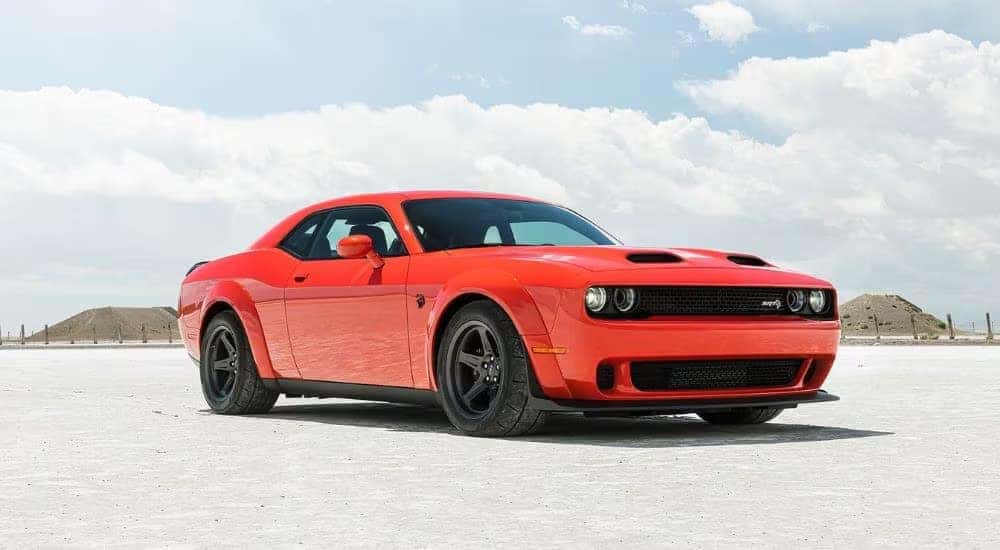 An orange 2023 Dodge Challenger SRT is shown driving to a Dodge dealer near Charlotte.