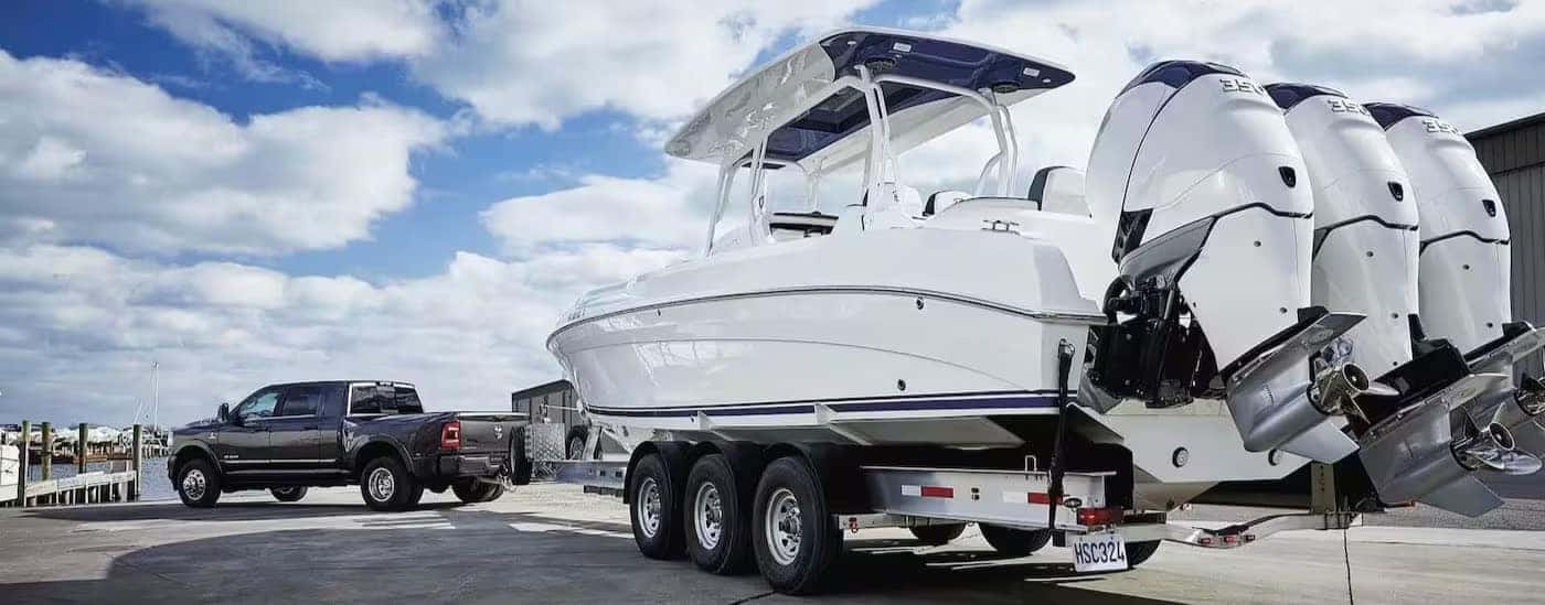 A black 2024 Ram 3500 towing a boat.