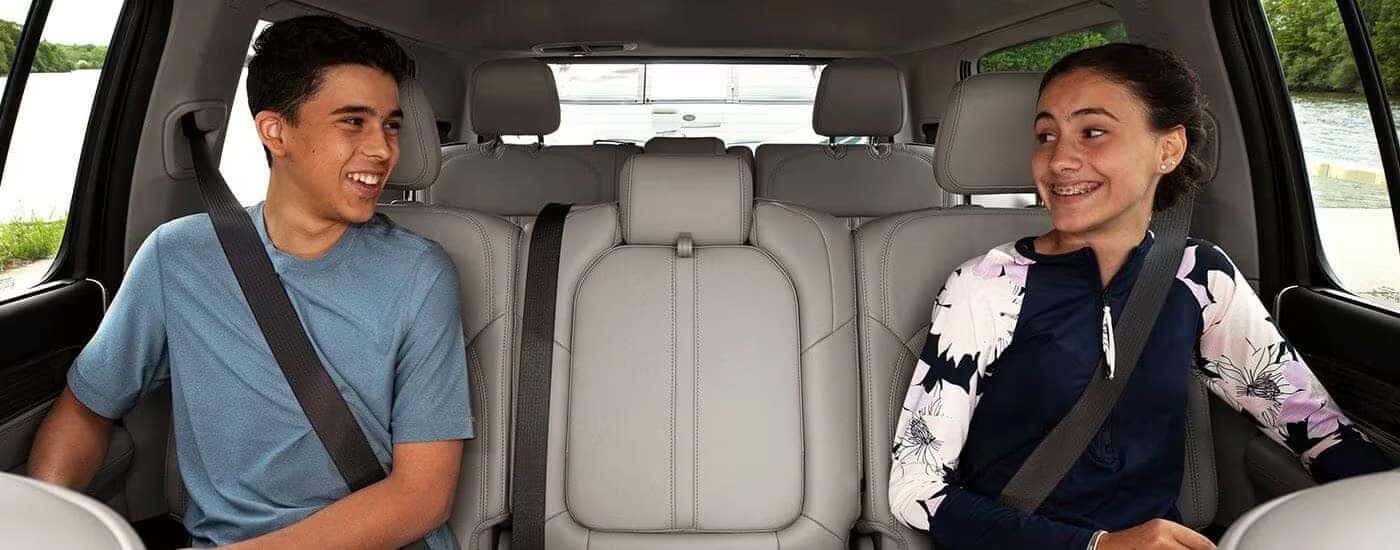 Smiling kids are shown sitting in a 2023 Jeep Wagoneer.