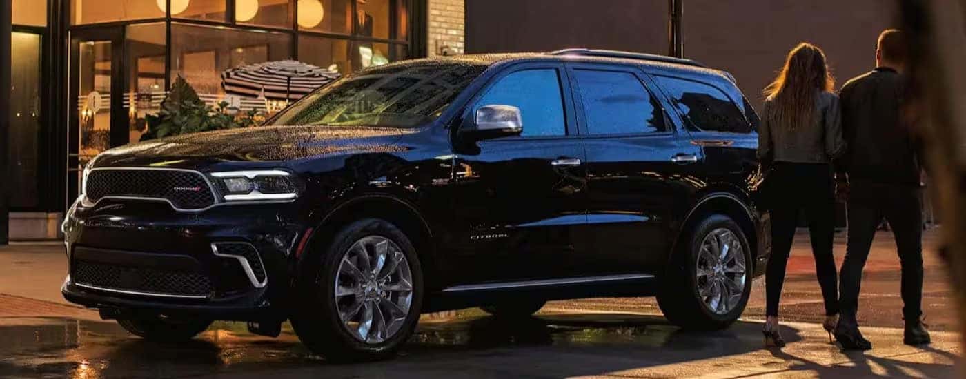 A black 2024 Dodge Durngo Citadel is shown parked on a rainy night.