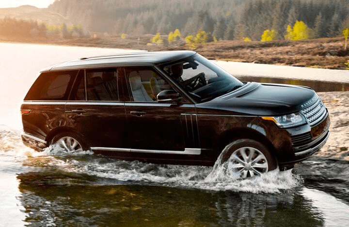 black Land Rover Range Rover fording a river