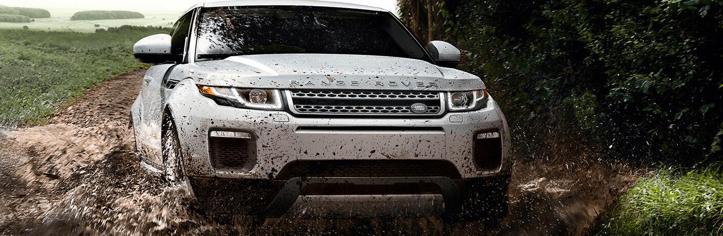white range rover driving through mud