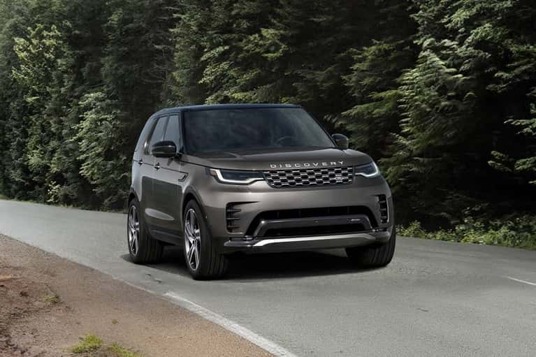 land-rover-discovery-driving-forest-highway-mobile
